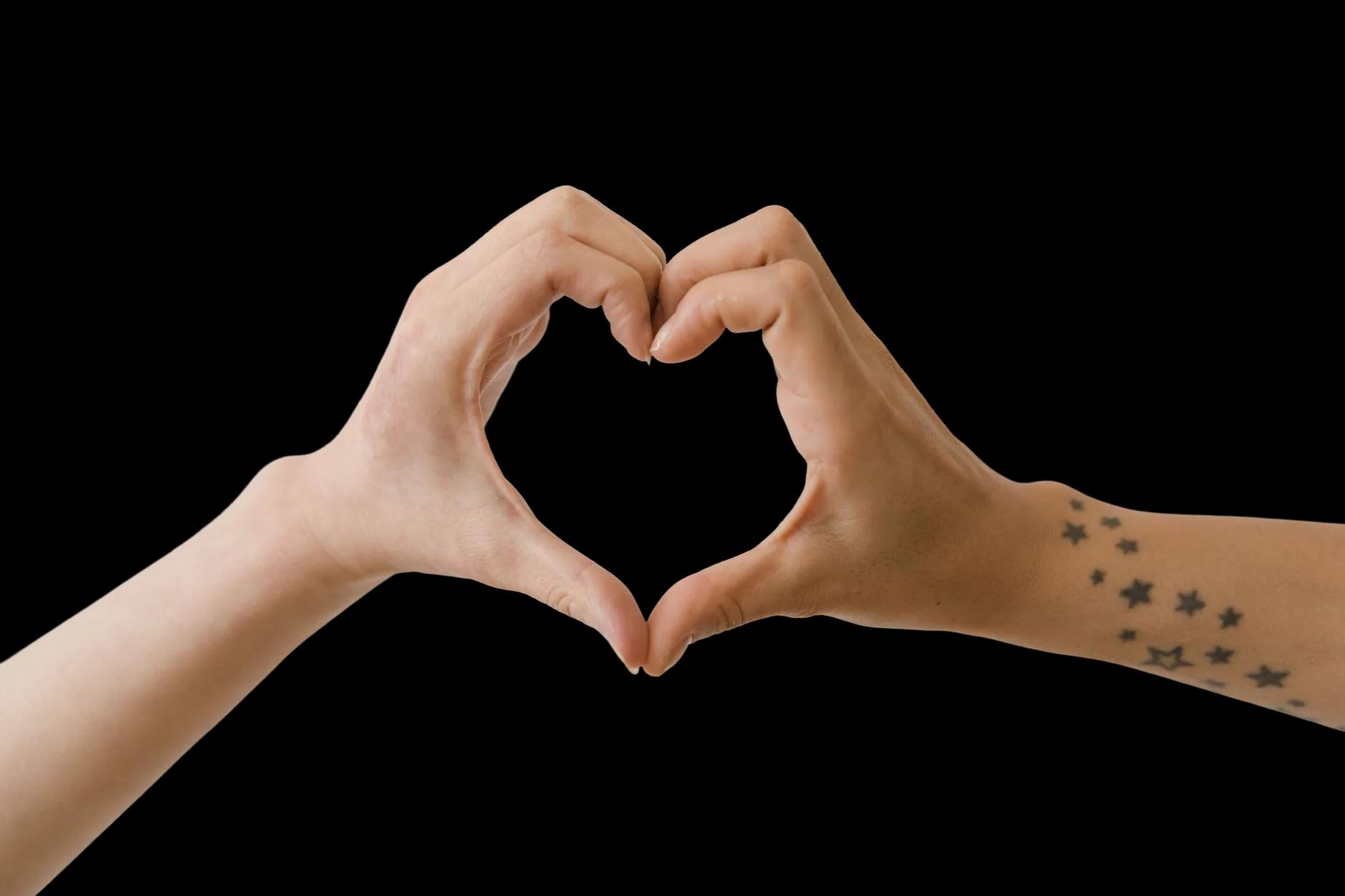 Two people forming a heart shape with their hands